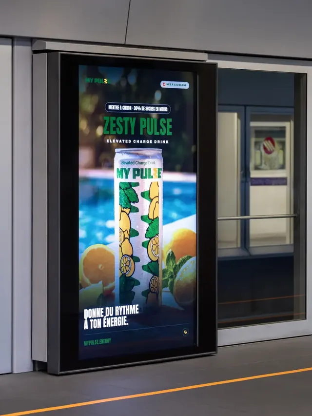 Panneau publicitaire numérique montrant une canette de boisson énergisante, dans un passage.