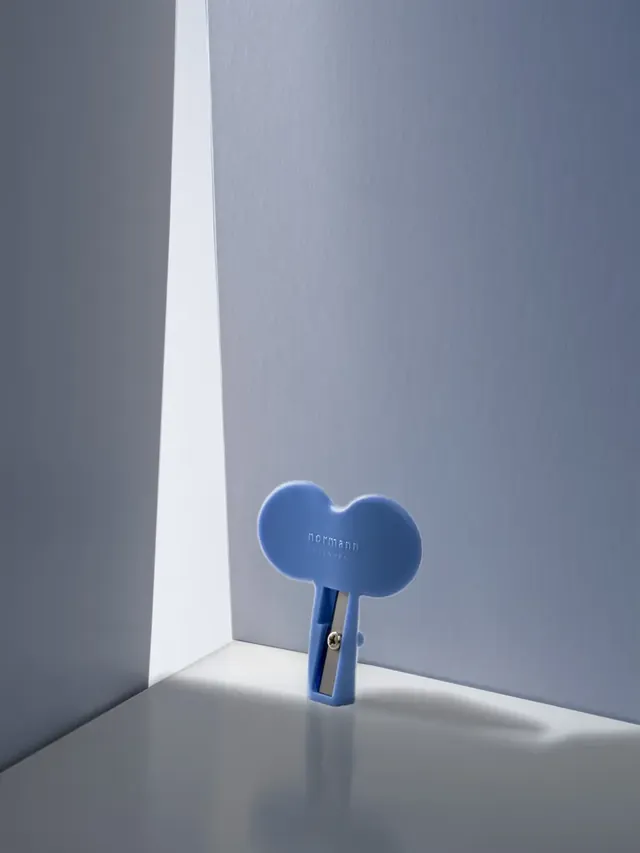 Petit objet bleu photographié dans un décor bleu, dans un rai de lumière.