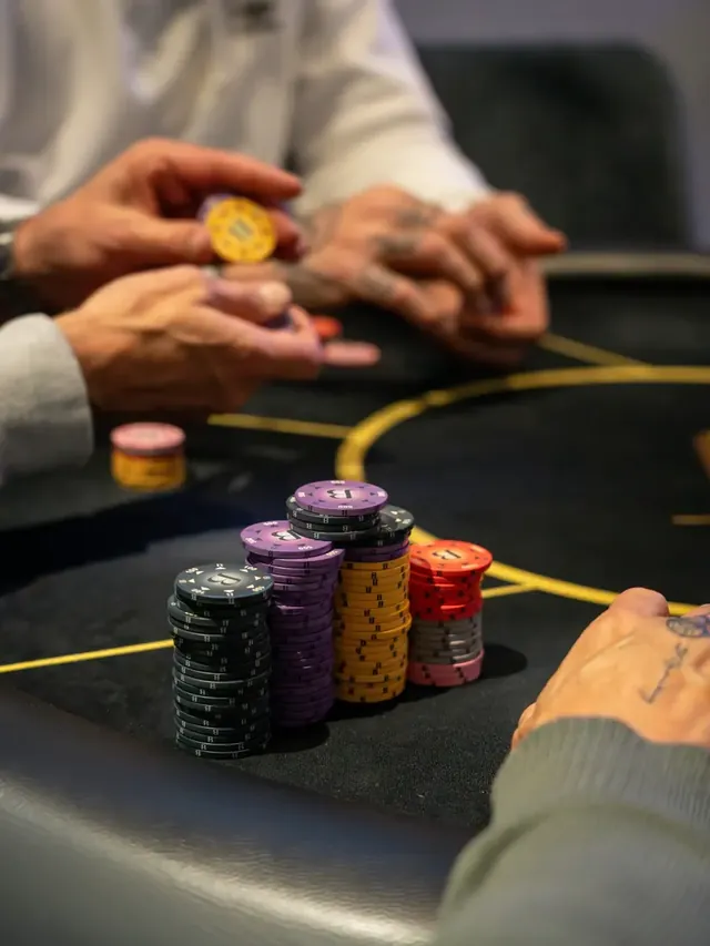 Mains de joueurs et piles de jetons pendant une partie.